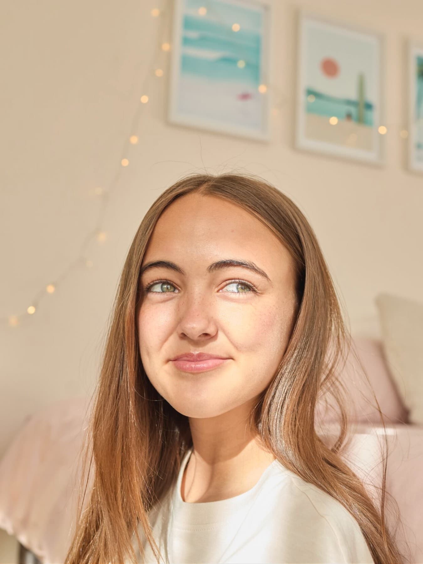 Lány ül egy szobában és kinéz az ablakon