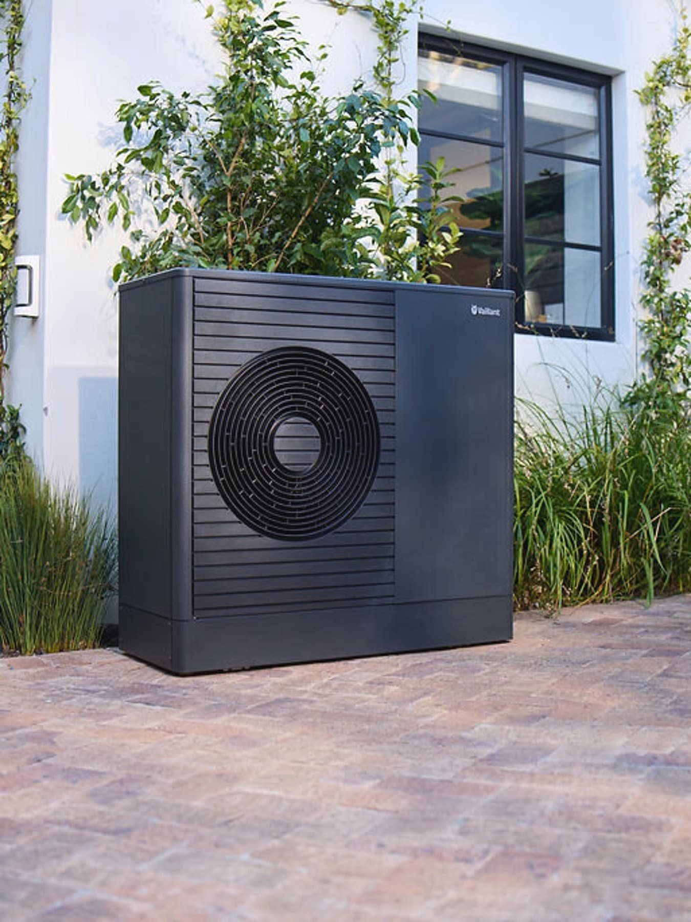 Dark Vaillant aroTHERM plus hőszivattyú egy ház előkertjében