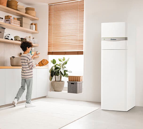 Egy kisfiú a Vaillant flexoCOMPACT exclusive készülékkel játszik a mosókonyhában