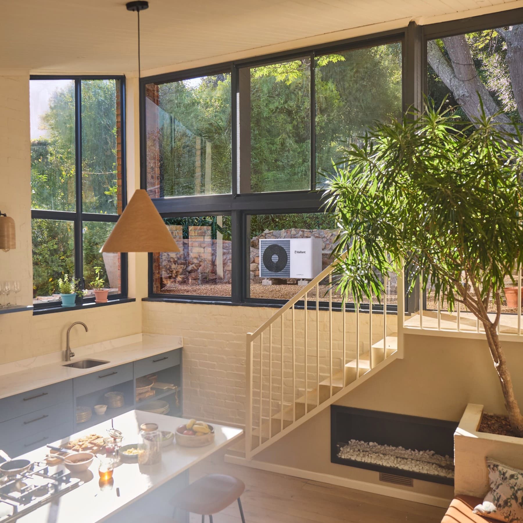 A kertben lévő Vaillant hőszivattyú az ablakon keresztül látható