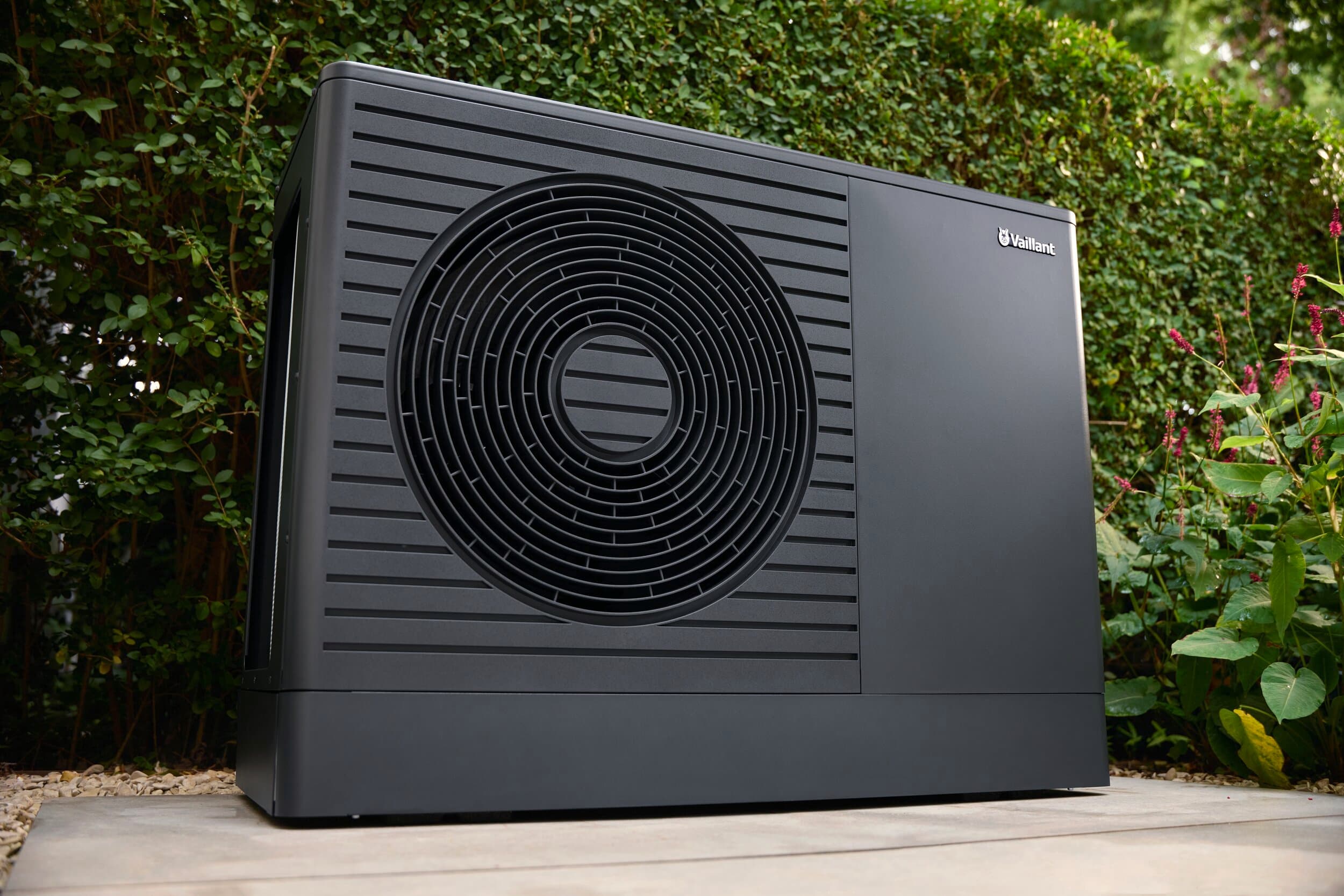 aroTHERM pro levegő–víz hőszivattyú egy sövény előtt